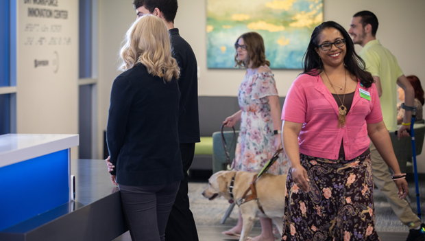 Many people walking in the Envision Workforce Innovation lobby while working