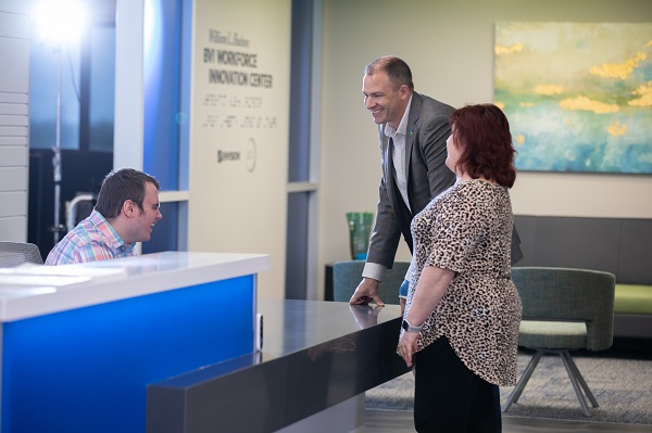 Two people checking in at the front desk of the WIC lobby