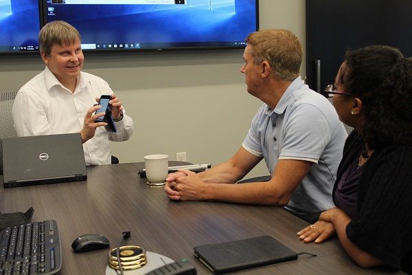 Man who is blind teaching others how to use a specific app on his phone