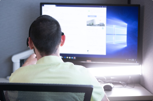 Man who is blind or visually impaired looking at a computer screen with a headset on