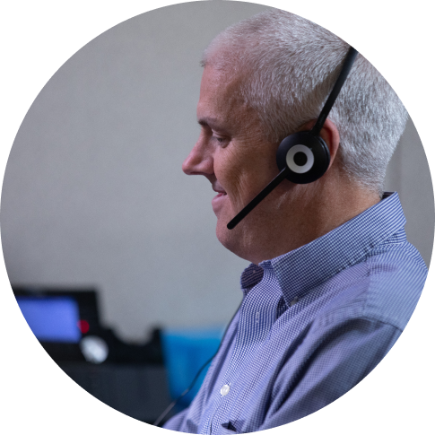 A call center representative smiling while talking to a customer.