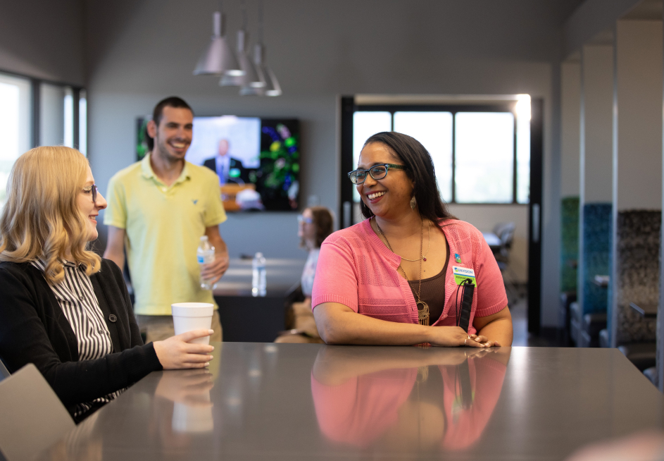 BVI employees gathered around a break table smiling and catching up with one another.